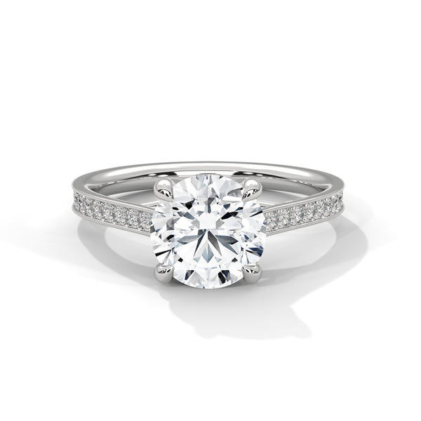 “Aurora Ring—round brilliant diamond sparkle, sleek pavé-band elegance, and timeless white-gold beauty crafted to symbolize radiant love, grace, and unforgettable moments.”