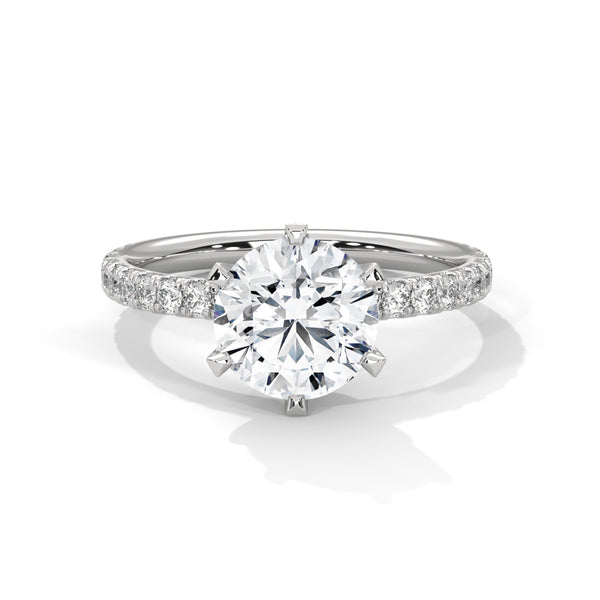 “Celestia Ring—round-cut diamond brilliance, secure six-prong elegance, and pavé-band sparkle crafted to symbolize timeless beauty, lasting love, and radiant sophistication.”