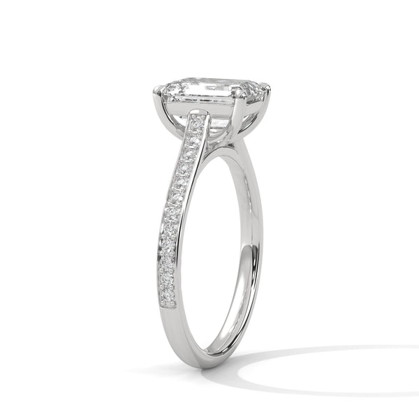 The Celestial Elegance Ring features a striking emerald-cut diamond embraced by a delicate band adorned with shimmering pave stones. A timeless piece that symbolizes everlasting love and sophistication.