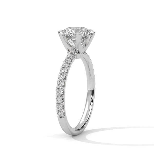“Celestia Ring—round-cut diamond brilliance, secure six-prong elegance, and pavé-band sparkle crafted to symbolize timeless beauty, lasting love, and radiant sophistication.”
