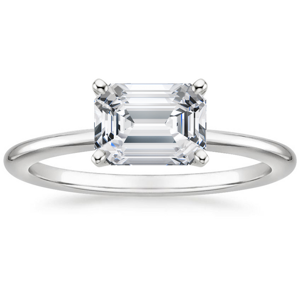 Solstice Grace is a minimalist masterpiece, showcasing an emerald-cut diamond in a classic four-prong setting with a smooth, polished band that radiates refined simplicity.