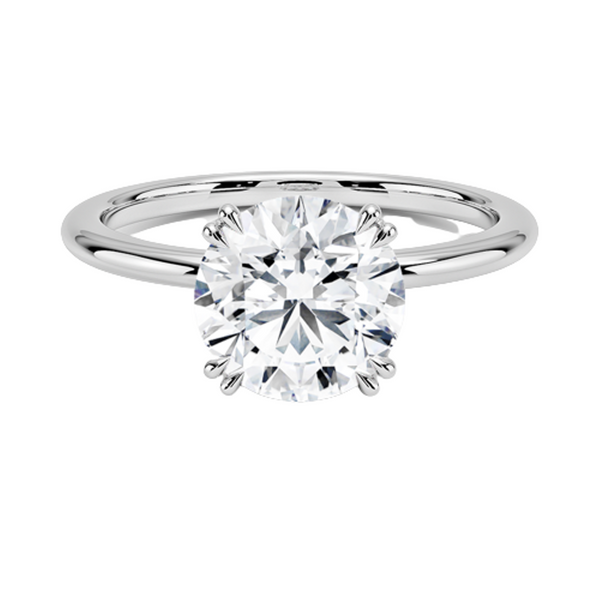 Elodie Whisper enchants with its delicate silhouette and double claw prongs that gently embrace a brilliant round diamond, floating effortlessly atop a slender white gold band.