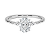 An icy-sleek three-stone ring crowned with a dazzling oval diamond that gleams like winter sunlight.