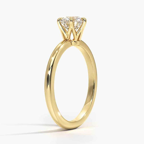 A refined solitaire ring featuring a round brilliant diamond held in a six-prong trellis setting, paired with a polished white gold band.