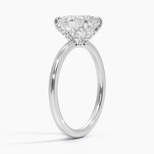 Celestia Crest features a stunning oval diamond elevated by a hidden halo and intricate claw prongs, set atop a high-polish band for a flawless blend of sparkle and sophistication.