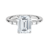 The Solmaris Crest ring showcases a commanding emerald-cut diamond framed by trapezoid side stones, exuding modern elegance and architectural beauty.