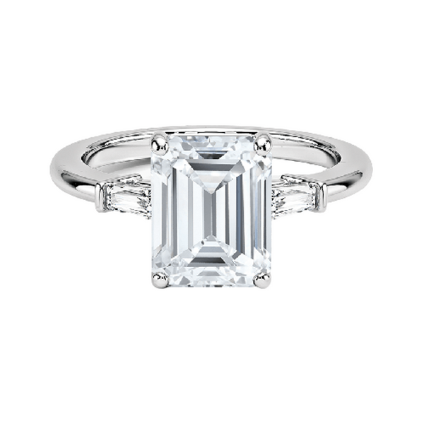 The Solmaris Crest ring showcases a commanding emerald-cut diamond framed by trapezoid side stones, exuding modern elegance and architectural beauty.