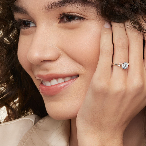 A round brilliant solitaire embraced by an intricate vine-inspired setting, intertwining elegance and organic artistry.