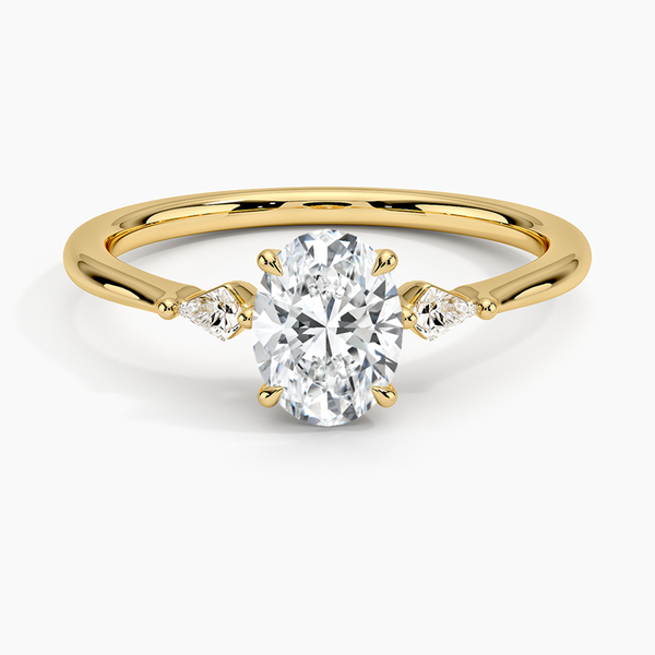 An icy-sleek three-stone ring crowned with a dazzling oval diamond that gleams like winter sunlight.