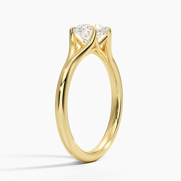 A modern solitaire with sculptural grace, the Seraphine Crest features elegantly arched prongs lifting a brilliant round diamond in a soft, sweeping embrace.