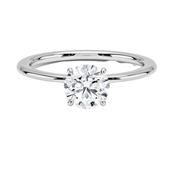 Celestia Crown radiates refined luxury, with a hidden halo of diamonds encircling the base of a dazzling round center stone in a sleek white metal setting.